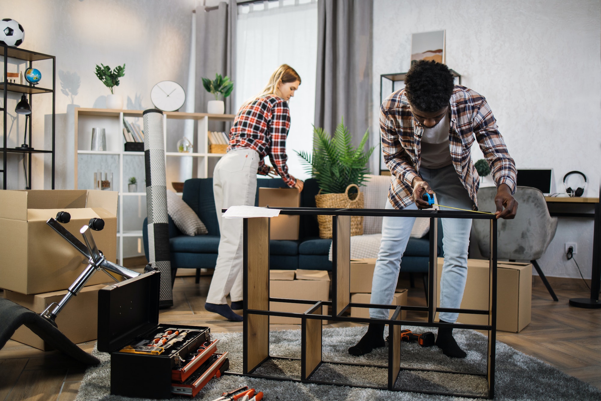 Family unpacking boxes and assembling furniture at new home